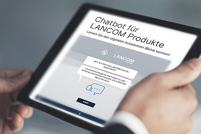 Tablet mit Webseitenansicht des digitalen Assistenten von LANCOM, festgehalten in zwei Händen