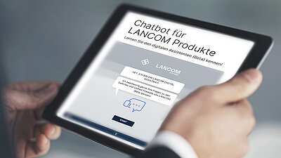 Tablet mit Webseitenansicht des digitalen Assistenten von LANCOM, festgehalten in zwei Händen