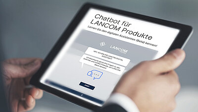 Tablet mit Webseitenansicht des digitalen Assistenten von LANCOM, festgehalten in zwei Händen